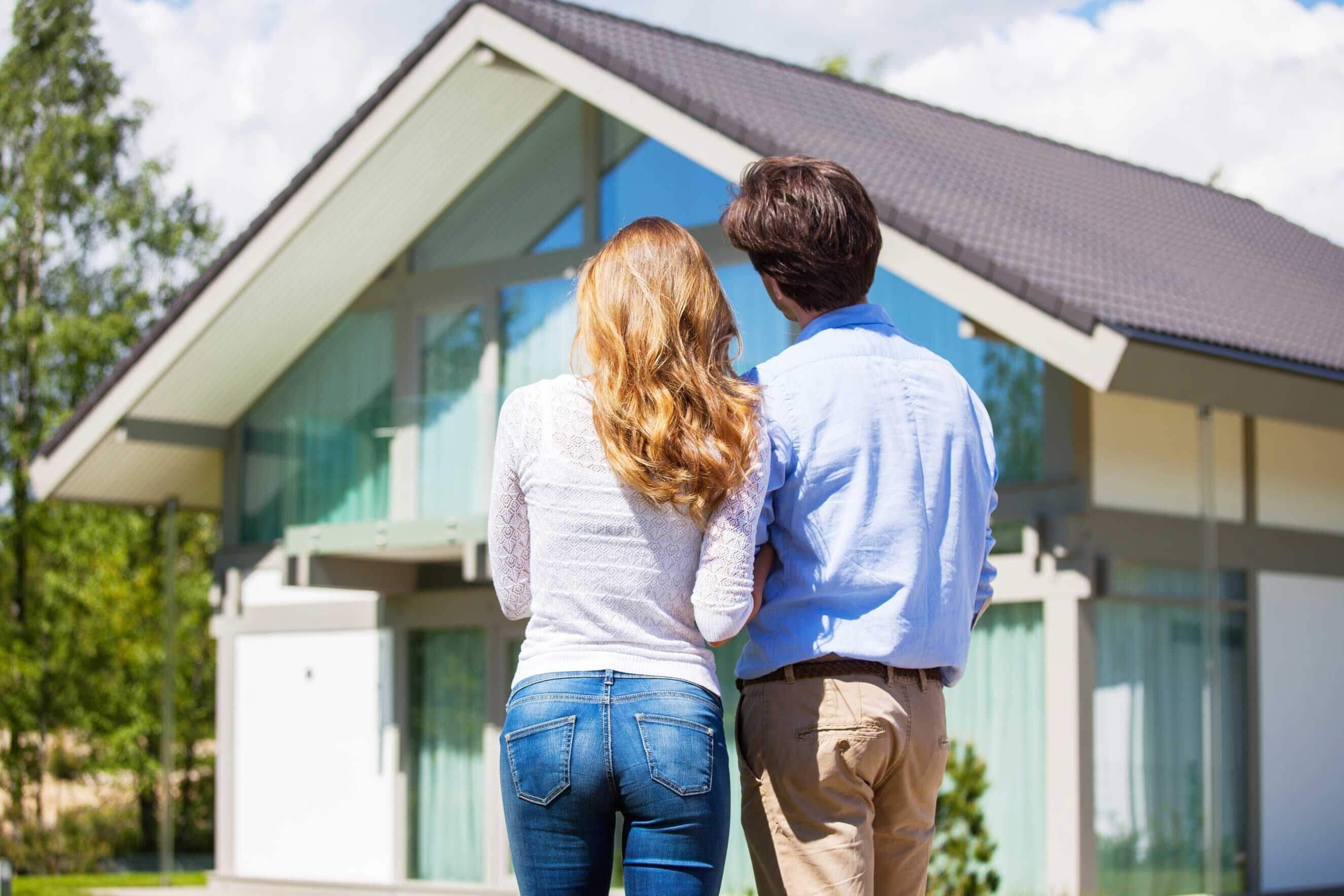 Couple standing in front of home