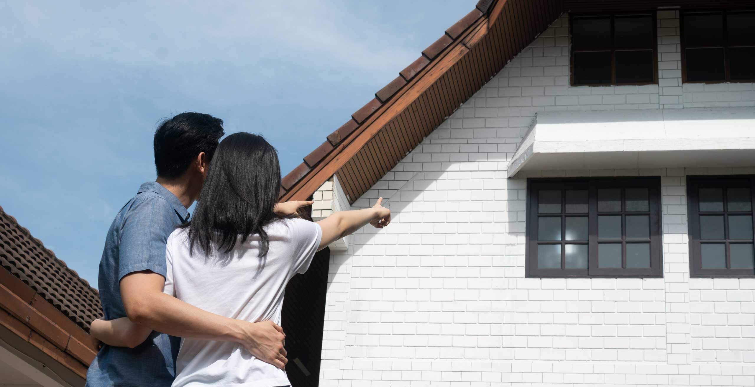 Couple pointing at a single family home